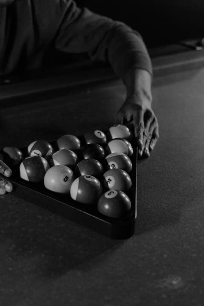 Close-up black and white photo of billiard balls racked, emphasizing the sport and precision.