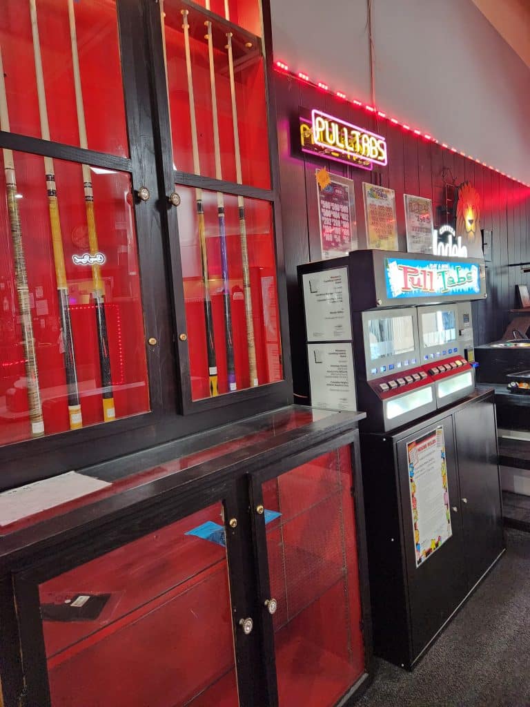 Cue display and pull tab gambling area at Jimmy’s Pro Billiards in Columbia Heights, Minnesota, where visitors enjoy top-tier pool and casual gaming